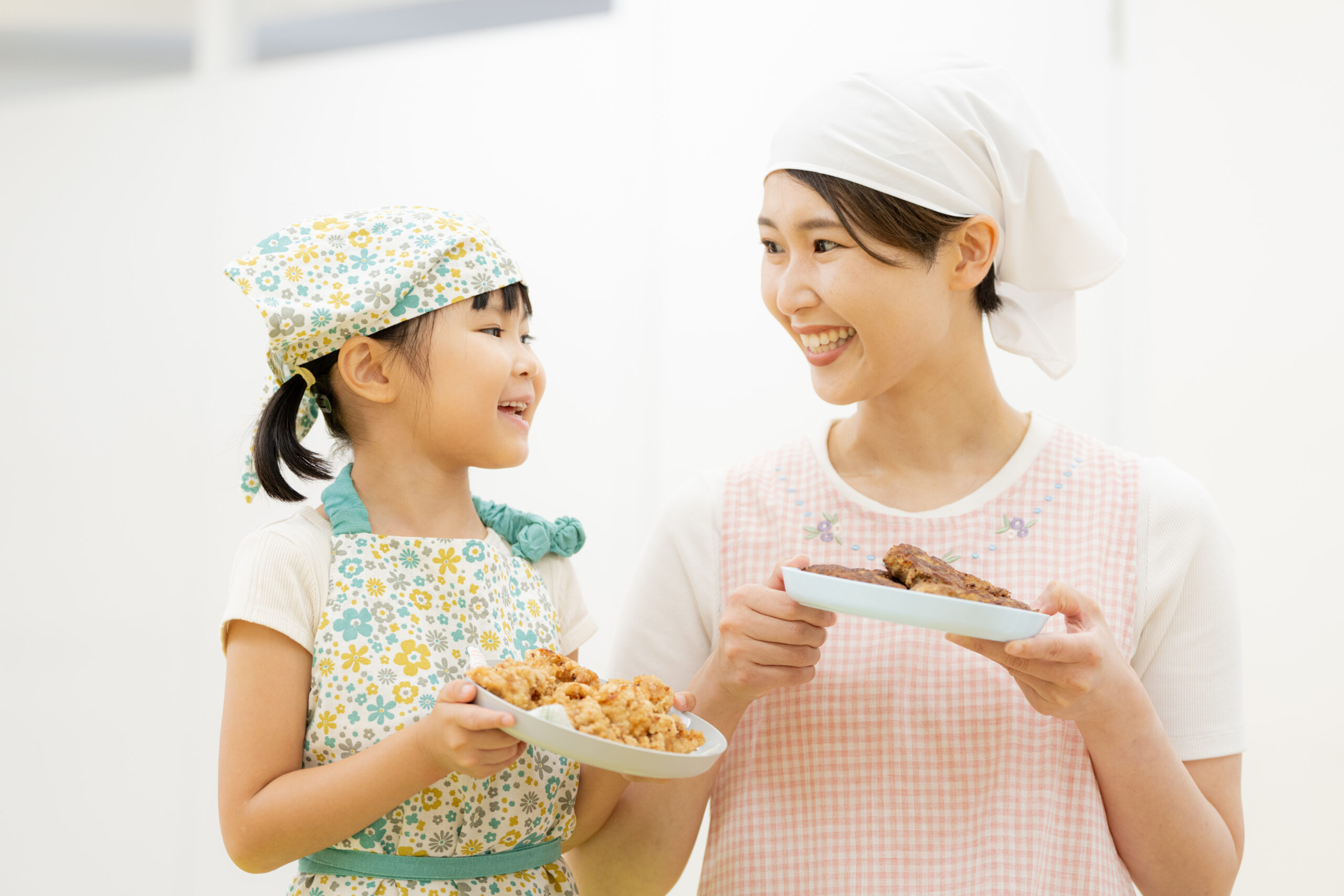 エプロンをして料理する母娘