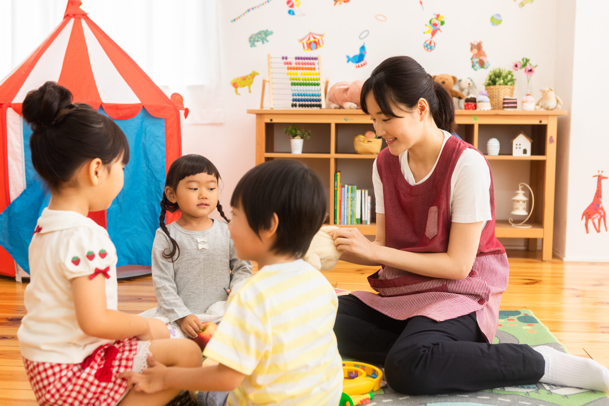 保育園で遊ぶ子供たちと保育士